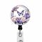 Purple butterfly on floral badge reel.
